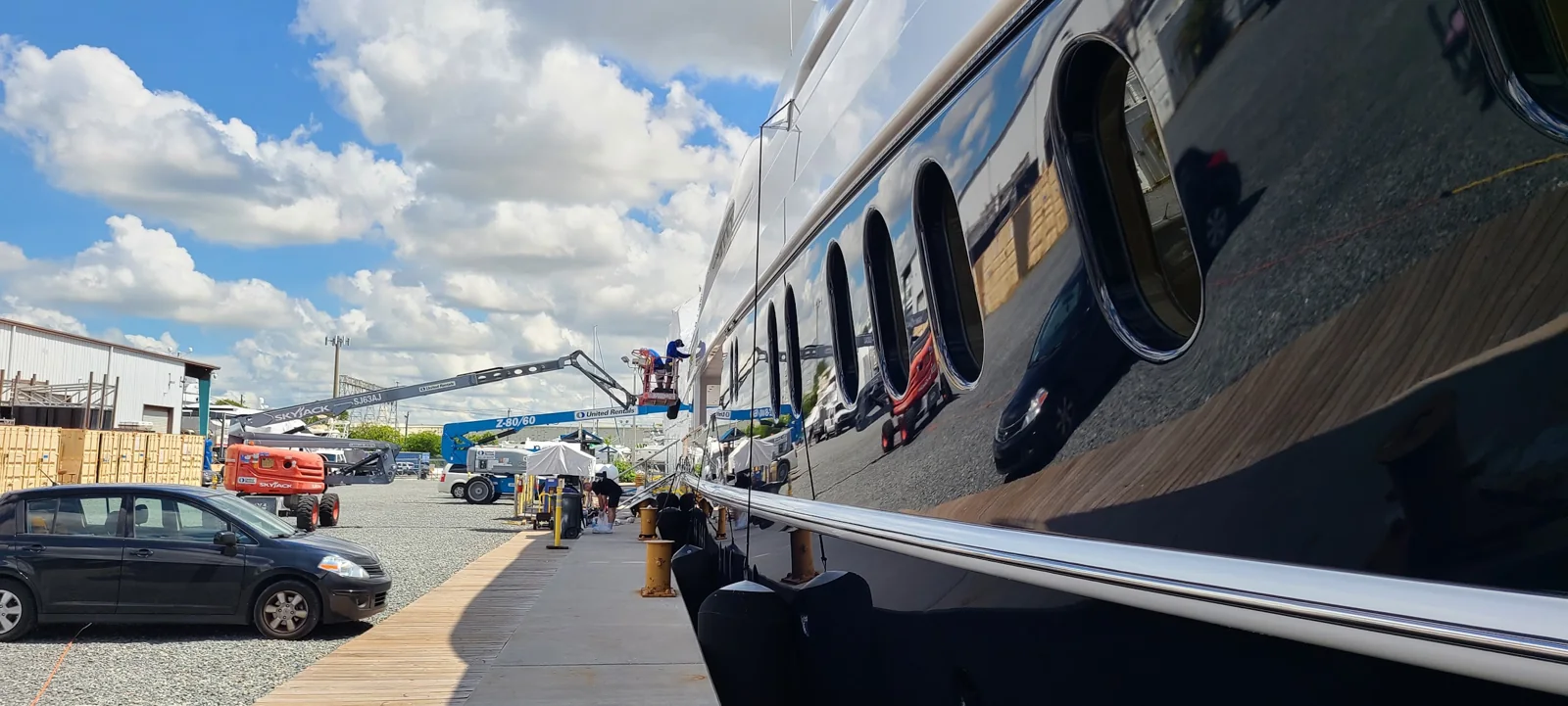 Extended man-lift access along a yacht hull for exterior polishing